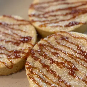 Shortbread rounds with caramel drizzle and powdered sugar