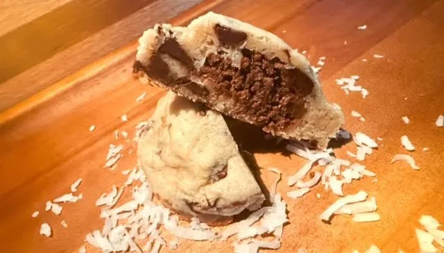 Coco Lava Chip cookie cut open revealing a molten chocolate coconut center
