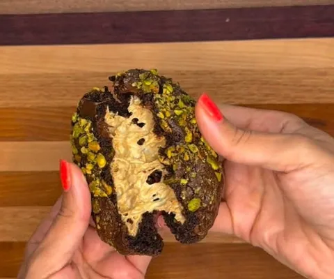 Dubai Crunch cookie split open showing molten pistachio cream filling and chopped pistachios