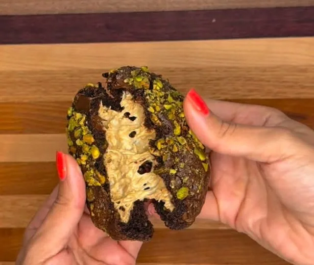 Dubai Crunch cookie split open showing molten pistachio cream filling and chopped pistachios