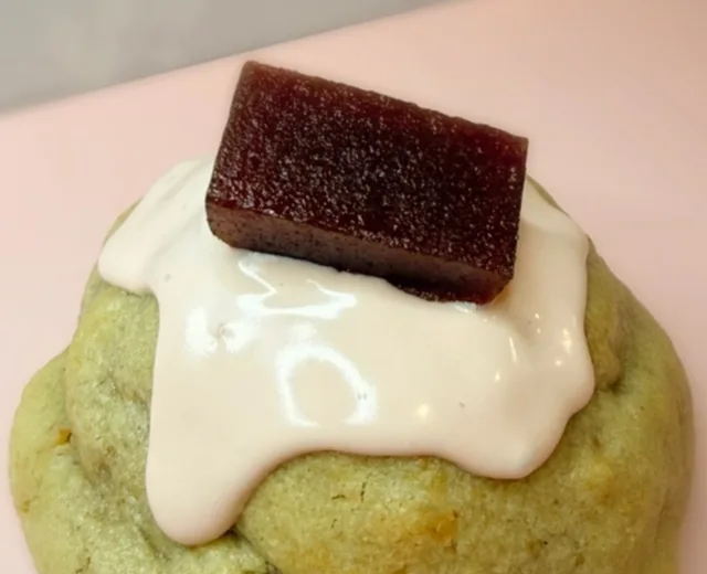 Guava stuffed cookie topped with cream drizzle and a slice of guava paste