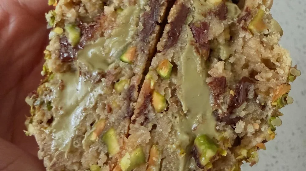 Dubai Crunch cookie held open showing pistachio cream filling